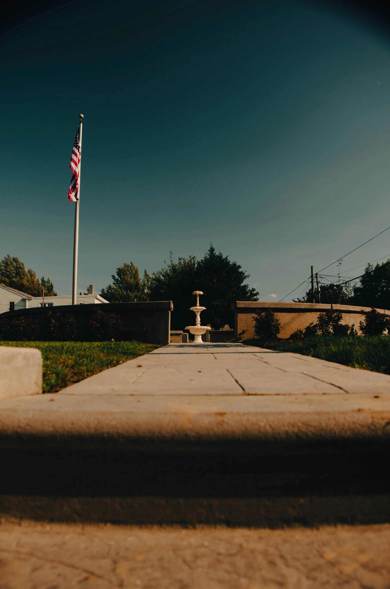 a red fire hydrant sitting on the side of a road, by Brad Holland, unsplash, realism, american flag in background, panoramic shot, fountain in the middle, ground level view of soviet town