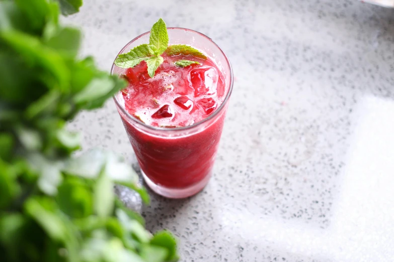 a close up of a drink in a glass on a table, red beryl, mint, 👰 🏇 ❌ 🍃, profile image