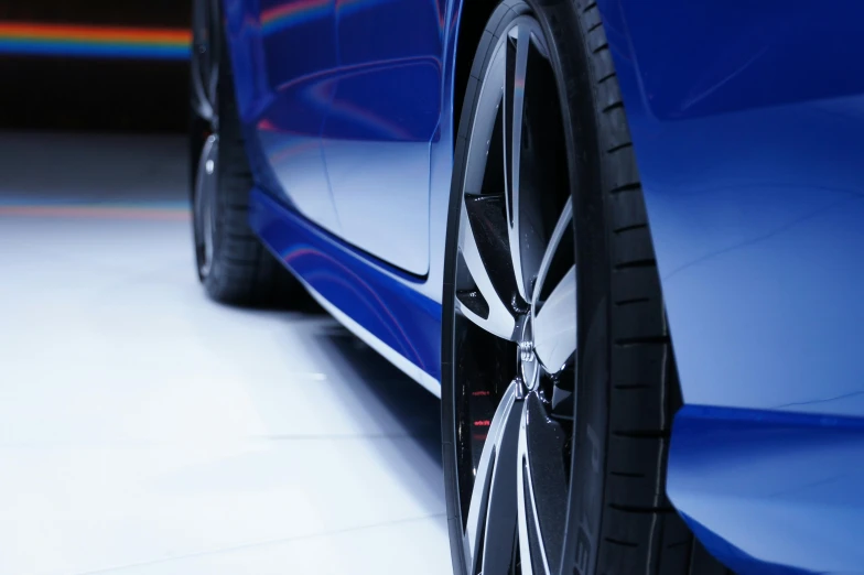 a close up of a tire on a blue car, a digital rendering, pexels contest winner, with a sleek spoiler, side lighting xf iq4, thumbnail, full body close-up shot