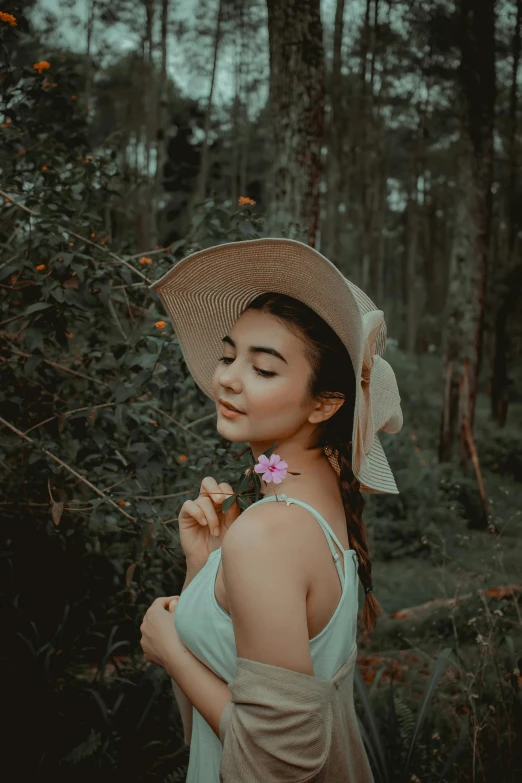 a woman wearing a hat and holding a flower, a colorized photo, inspired by Tan Ting-pho, pexels contest winner, sumatraism, forest setting, avatar image, cute young woman, casual