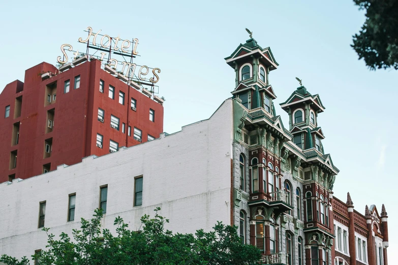 a tall building with a clock on top of it, by Carey Morris, pexels contest winner, art nouveau, harlem, two towers, stephen shore & john j. park, red building