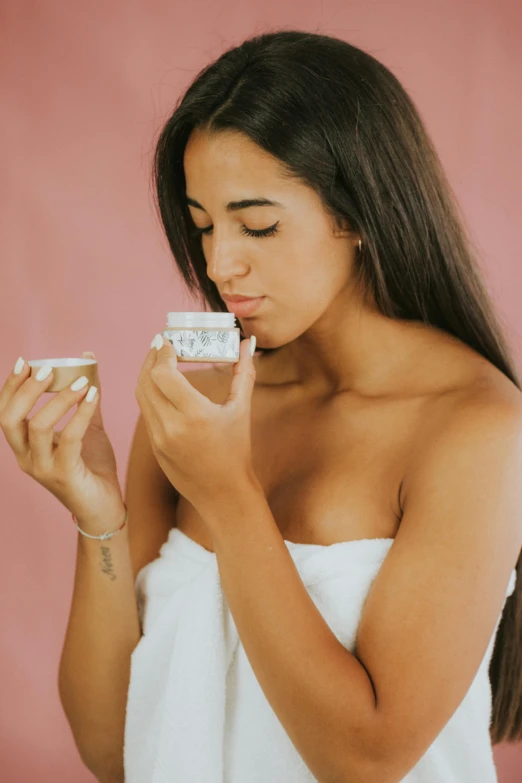 a woman in a towel holding a glass of water, by Olivia Peguero, trending on pexels, renaissance, putting on lipgloss, holding a boba milky oolong tea, apothecary, latina skin