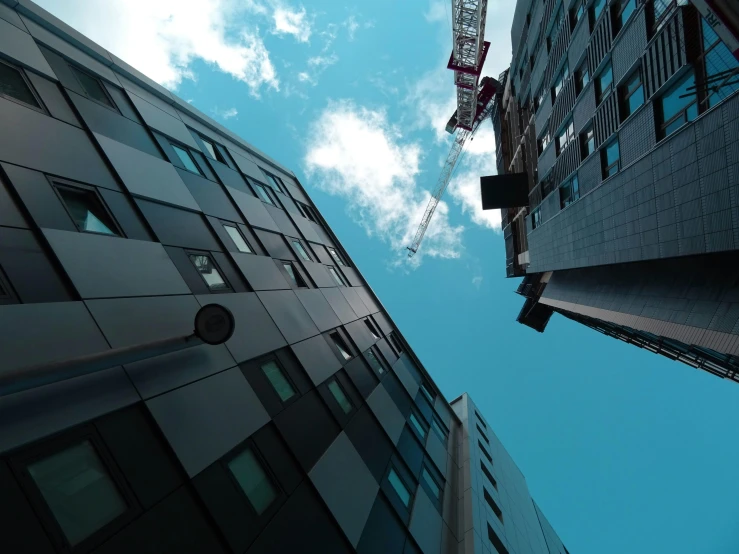 a couple of tall buildings next to each other, by Lee Loughridge, pexels contest winner, modular constructivism, sitting in a crane, floating in the air, thumbnail, wide angle exterior 2022