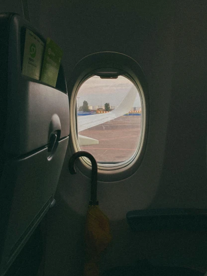 an airplane window with a view of a runway, pexels contest winner, facing away from the camera, plain background, profile pic, in suitcase
