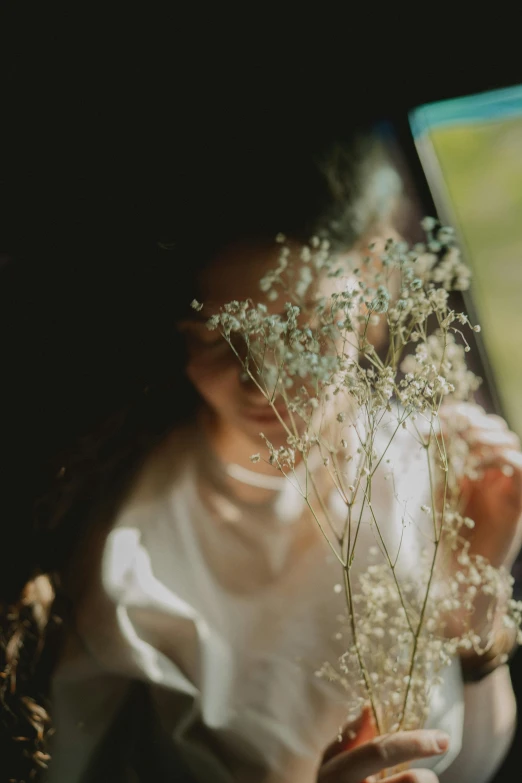 a close up of a person holding a bunch of flowers, a picture, inspired by Elsa Bleda, romanticism, window light, gypsophila, portrait featured on unsplash, car shot