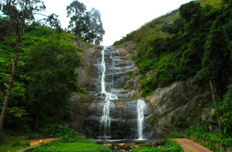 a waterfall in the middle of a lush green forest, hurufiyya, bangalore, festivals, fan favorite, facing front