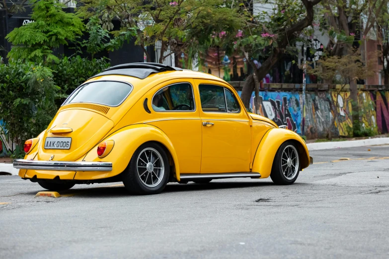 a yellow vw beetle parked on the side of the road, by Sven Erixson, pexels contest winner, wide body, avatar image, in sao paulo, profile image