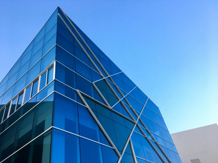 a very tall building with a lot of windows, a photo, unsplash, modernism, reykjavik junior college, clear blue sky, profile image, lit. 'the cube'