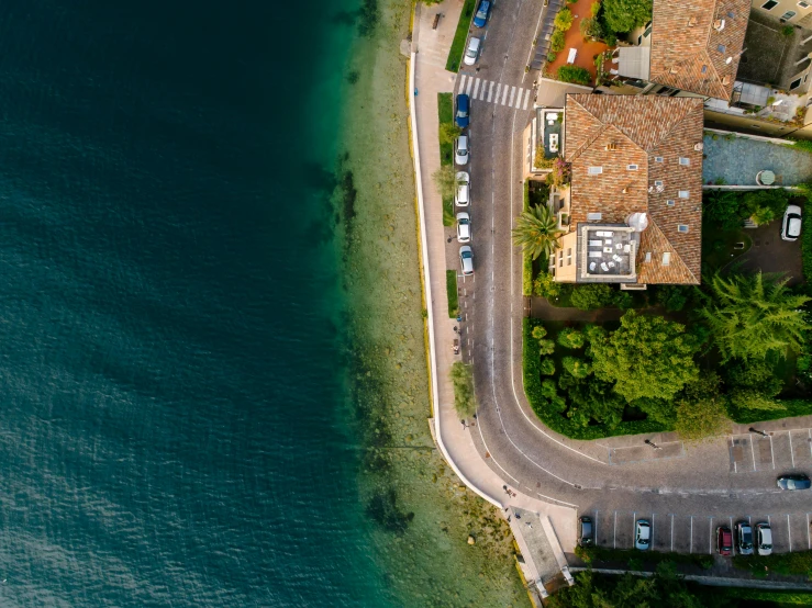 an aerial view of a road next to a body of water, pexels contest winner, photorealism, italian mediterranean city, thumbnail, drone photograpghy, split near the left