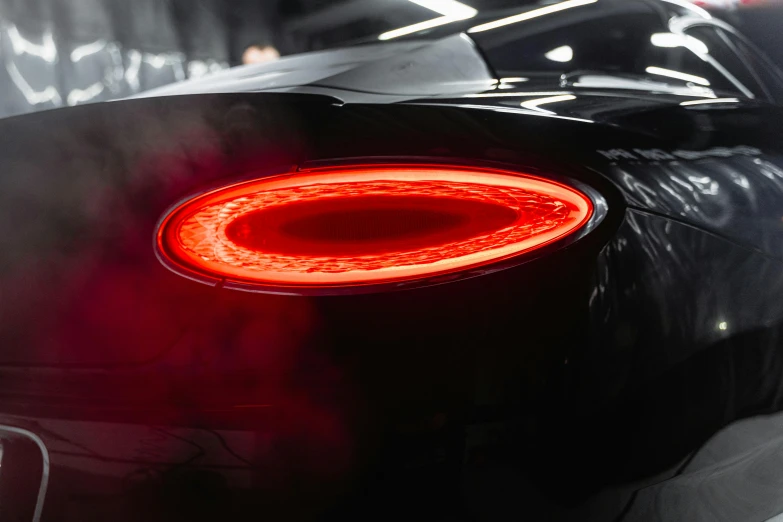 a close up of the tail lights of a car, by Tom Bonson, pexels contest winner, bentley, glowing halo, chiron, behind the scenes