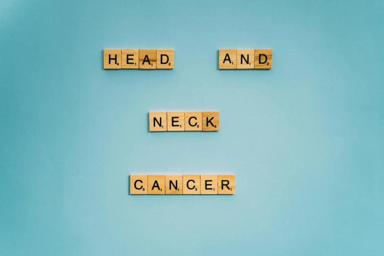 scrabbles spelling head and neck cancer on a blue background, pexels contest winner, neo-dada, wide neck, rex orange county, 1 / 3 headroom, hospital