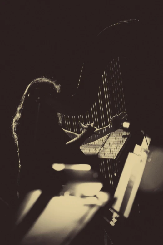 a woman playing a harp in the dark, an album cover, by Andrew Stevovich, happening, desaturated!, live in concert, synth vibe, ::