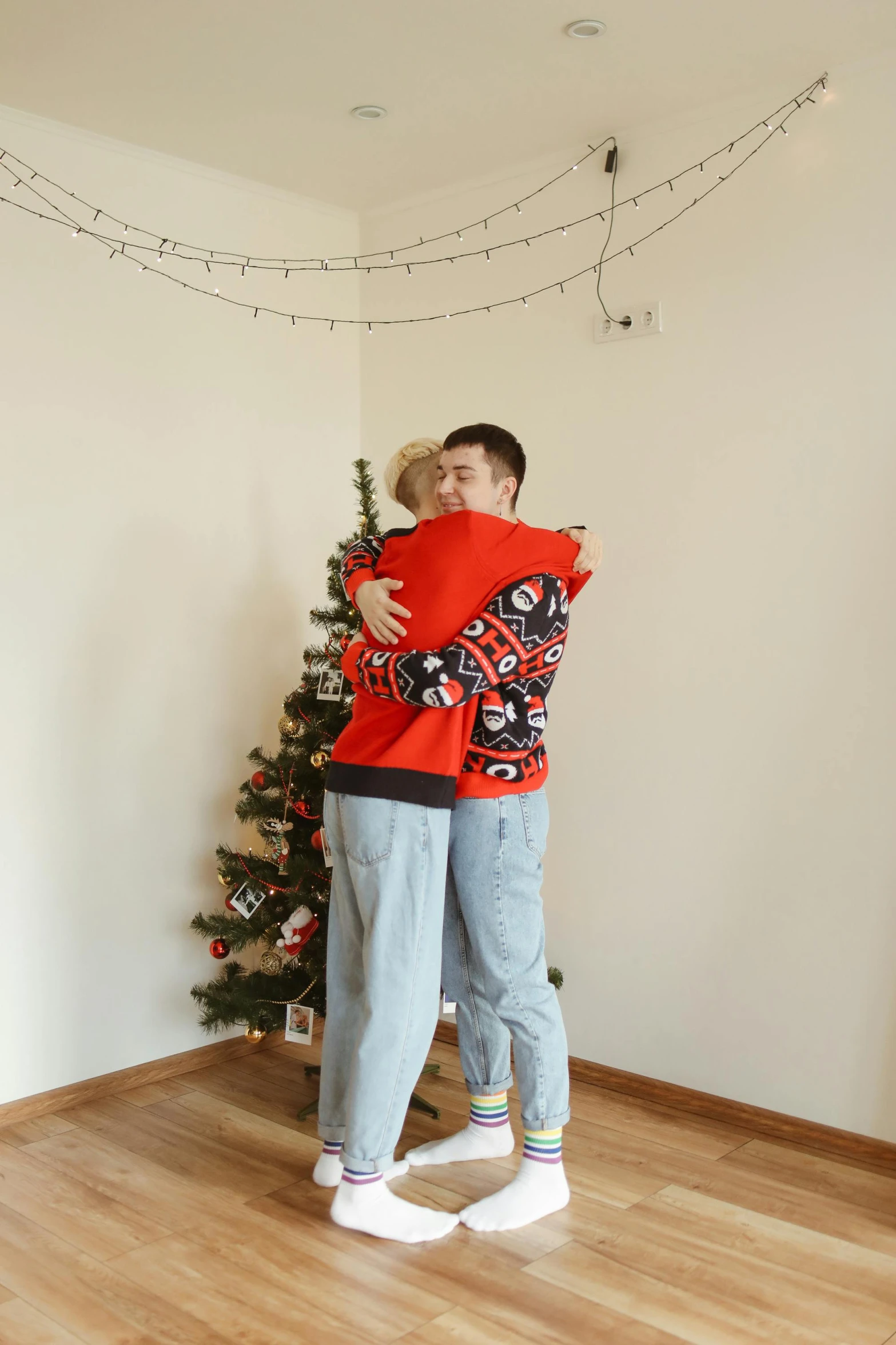 a man and a woman hugging in front of a christmas tree, a photo, pexels, realism, full body image, teenage boy, gif, sweater