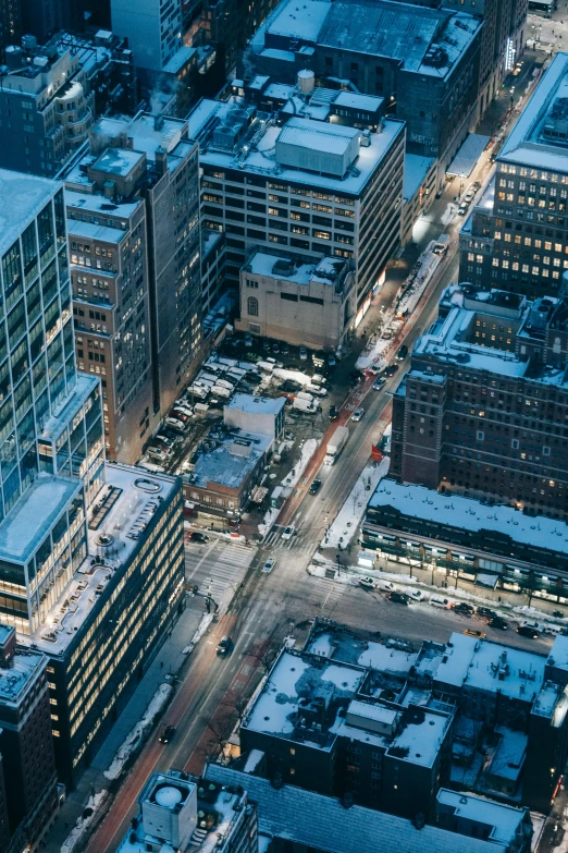 an aerial view of a city at night, pexels contest winner, snow and ice, modern city street, montreal, stacked buildings