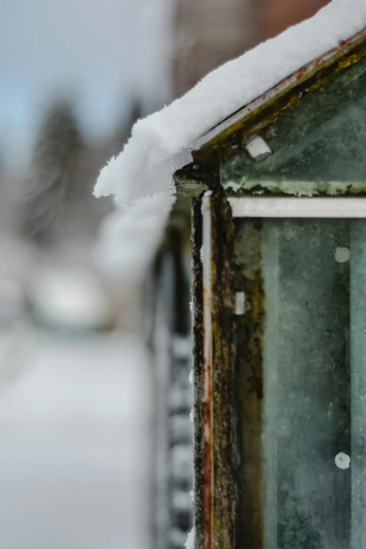 a close up of a building with snow on the roof, an album cover, by Jaakko Mattila, unsplash, rusty, a green, greenhouse in the background, today\'s featured photograph 4k