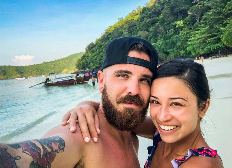 a man and woman taking a selfie on the beach, bald with short beard, wearing shipibo tattoos, thailand, avatar image