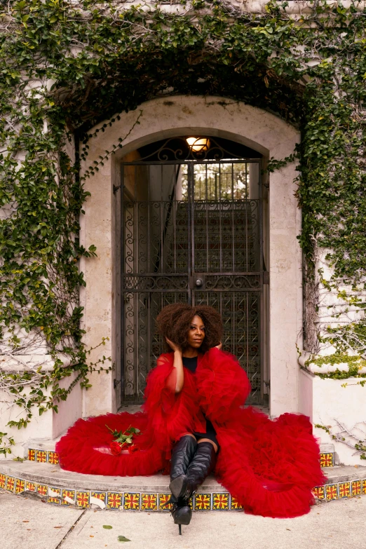 a woman in a red dress sitting on a step, an album cover, inspired by Carrie Mae Weems, pexels contest winner, renaissance, fluffy fluffy fur, lush surroundings, voluminous sleeves, vine covered