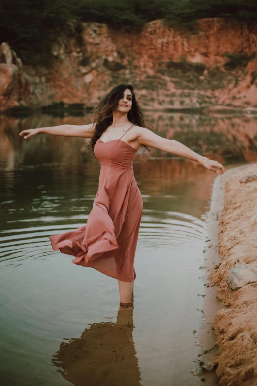 a woman in a pink dress standing in a body of water, pexels contest winner, renaissance, doing a sassy pose, warm muted colors, red river, near pond