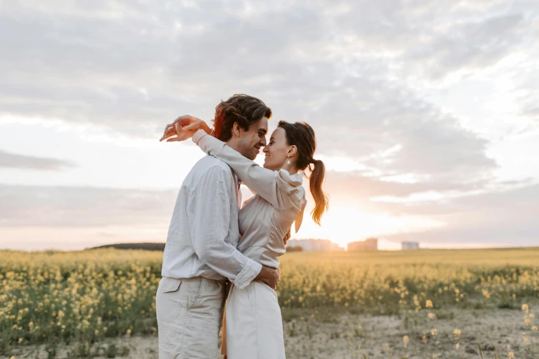 a man and woman standing next to each other in a field, pexels contest winner, making out, white, ad image, spring evening
