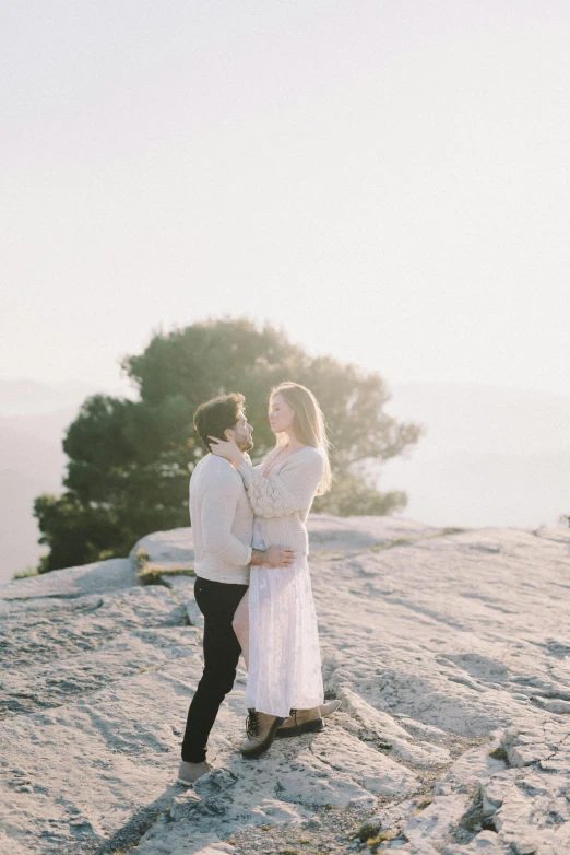 a man and woman standing on top of a mountain, unsplash contest winner, romanticism, delicate soft hazy lighting, over a calanque, white, bright ”