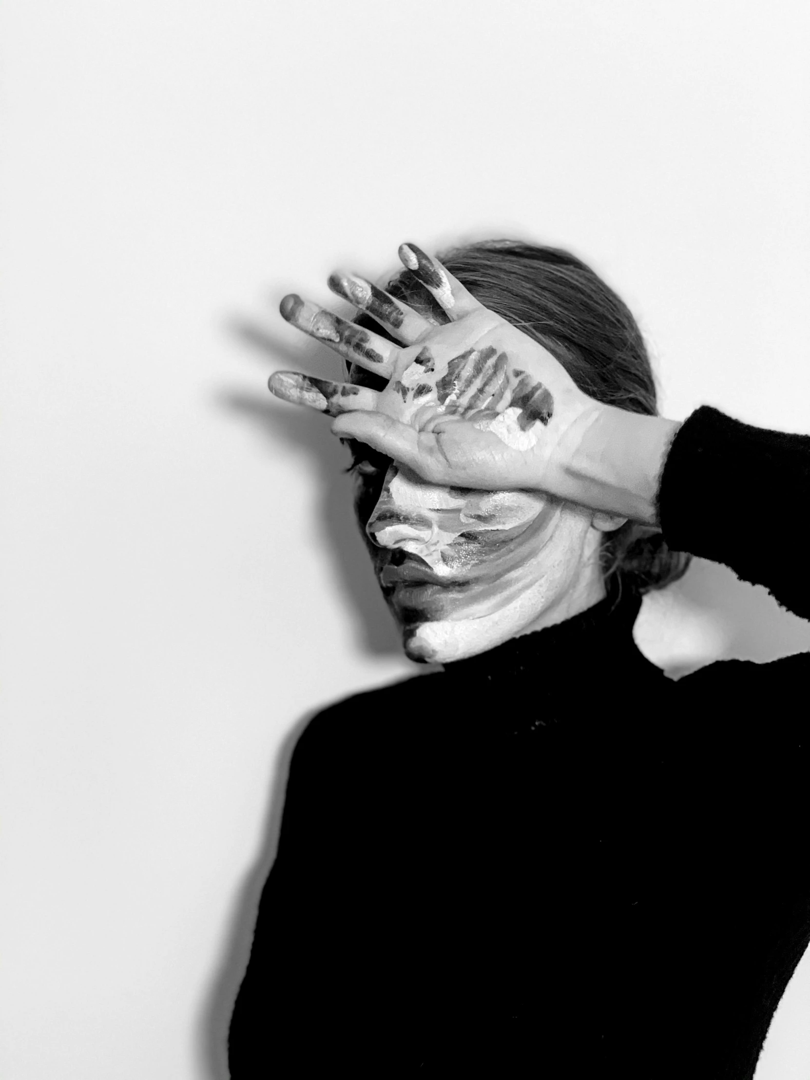 a black and white photo of a woman covering her face with her hands, a black and white photo, by Emma Andijewska, hyperrealism, facepaint facepaint facepaint, petra cortright, scars on face, photograph taken in 2 0 2 0