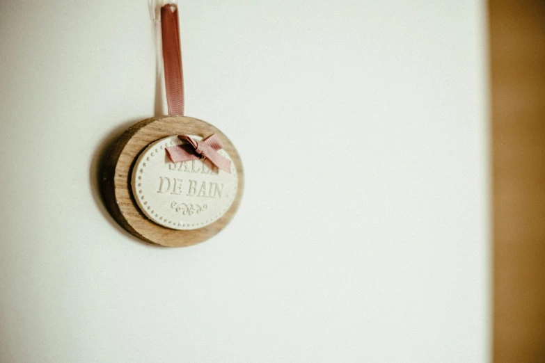 a close up of a clock on a wall, by Andrée Ruellan, les nabis, wooden decoration, ribbon, soft vignette, darling