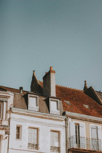 a tall building with a clock on top of it, a screenshot, by Andrée Ruellan, pexels contest winner, neoclassicism, simple gable roofs, northern france, rooftop romantic, sitting in french apartment
