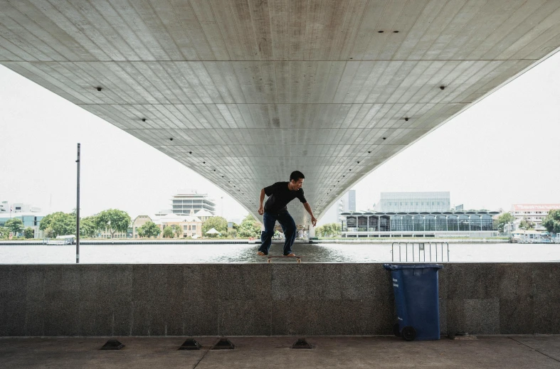 a man riding a skateboard on top of a cement wall, by Ryan Pancoast, unsplash contest winner, concrete art, standing on the water ground, sweeping arches, working hard, nanae kawahara