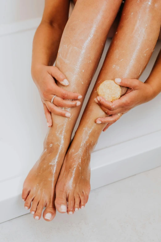 a woman washing her legs in a bathtub, pexels, with lemon skin texture, dry brushing, sparkly, woman holding another woman