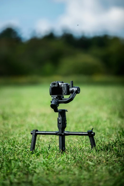 a camera sitting on top of a tripod in a field, phantom grip, game ready, frontal shot, hasselblade wide shot