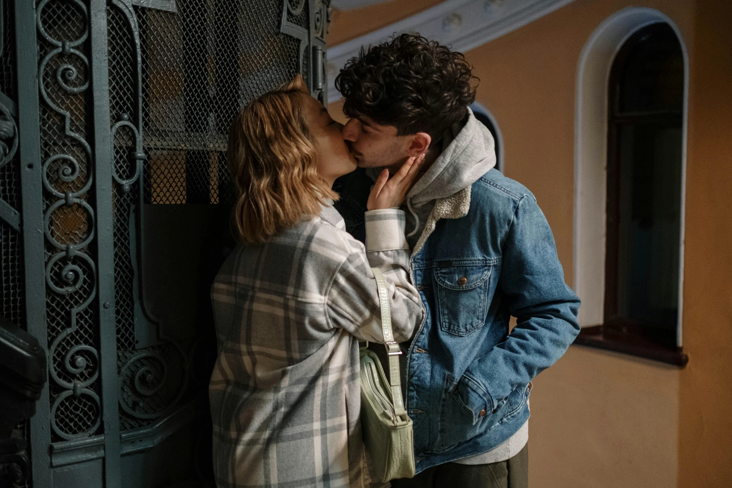 a man and a woman kissing in front of a gate, trending on pexels, timothee chalamet, aleksander rostov, about to enter doorframe, lesbians