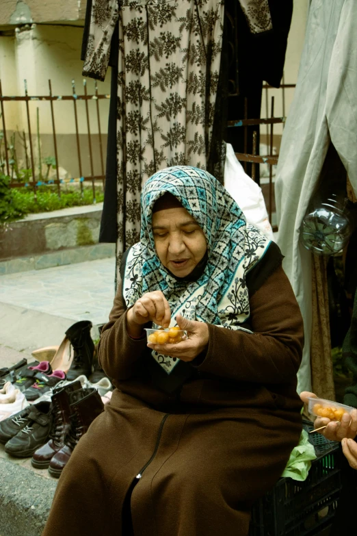 a couple of women sitting next to each other eating food, inspired by Modest Urgell, hurufiyya, crafts and souvenirs, square, donut, from egypt