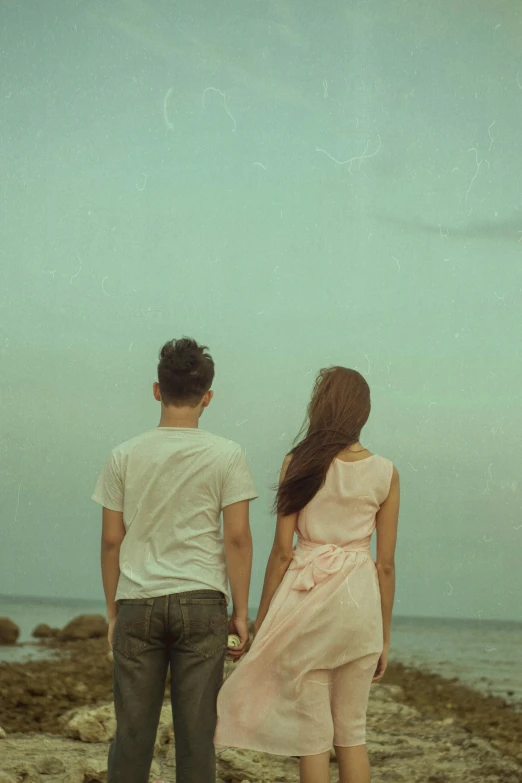 a man and a woman standing on a rocky beach, unsplash, romanticism, faded color film, illustration », back - shot, friends