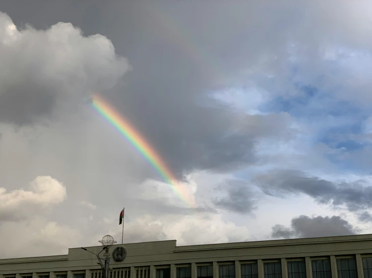 a rainbow is in the sky over a building, by Daren Bader, hurufiyya, parliament, low quality photo, stacked image, enes dirig