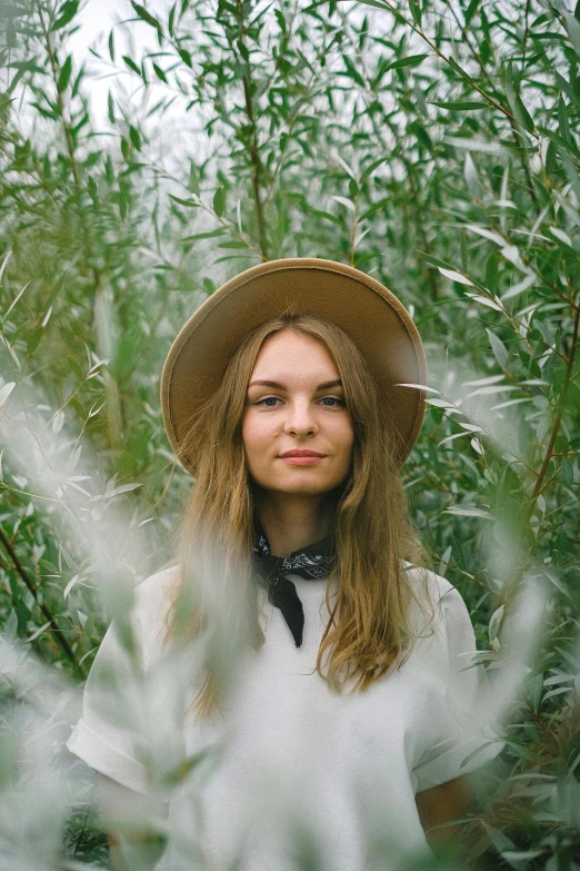 a woman wearing a hat standing in a field, pexels contest winner, portrait of sanna marin, with soft bushes, angelina stroganova, headshot