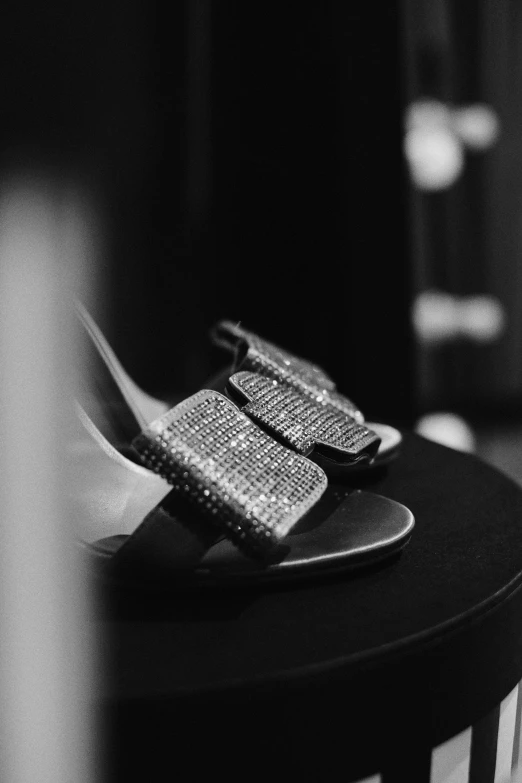 a pair of shoes sitting on top of a table, bling, icon black and white, straps, detail shot