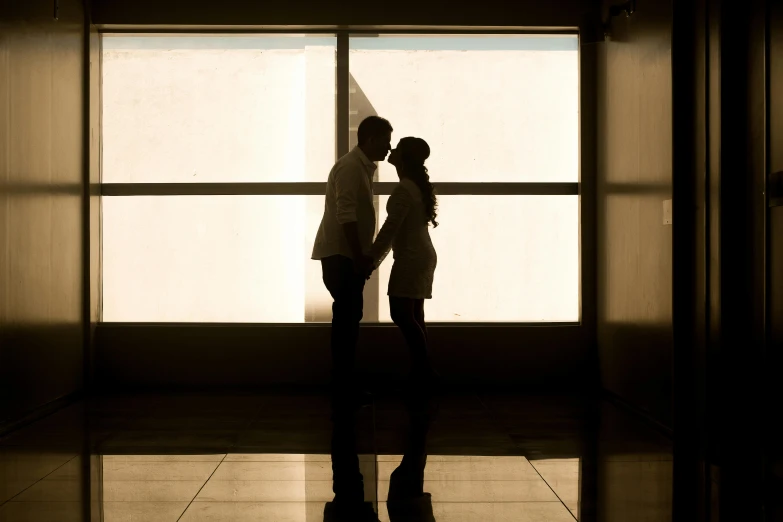 a man and a woman standing in front of a window, inspired by Jerry Schatzberg, pexels contest winner, backlit, lovers, modern, silhouetted