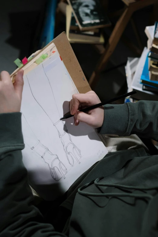a person laying on the floor drawing on a piece of paper, a child's drawing, inspired by Sarah Lucas, trending on pexels, stands at a his easel, weta workshop, close-up on legs, student