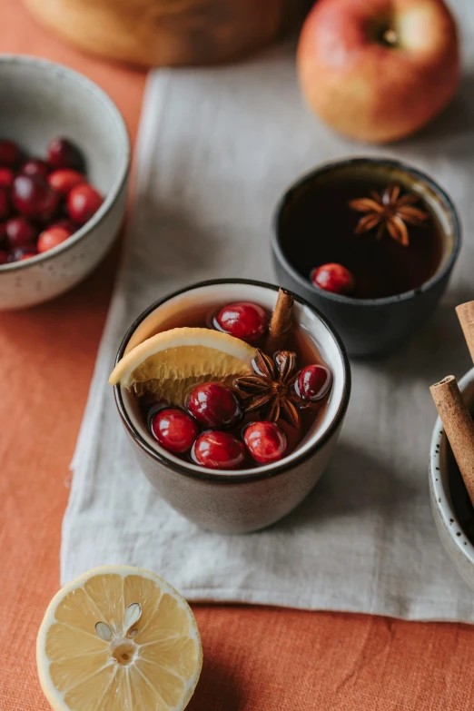 a close up of bowls of food on a table, a still life, by Anna Haifisch, trending on pexels, hot cocoa drink, red wine, square, festive