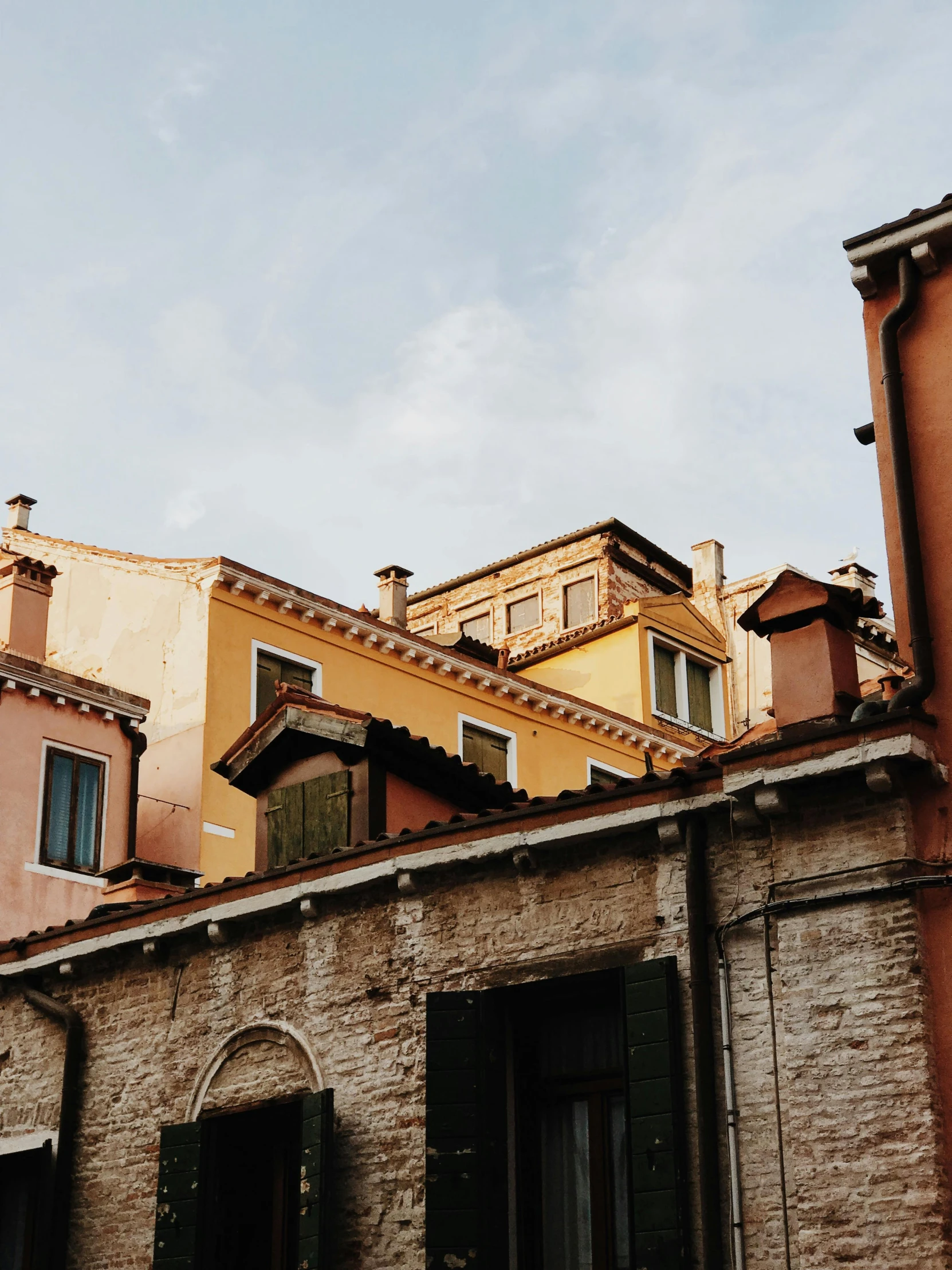 a couple of buildings that are next to each other, inspired by Jacopo Bellini, pexels contest winner, renaissance, simple gable roofs, conde nast traveler photo, neighborhood, brown