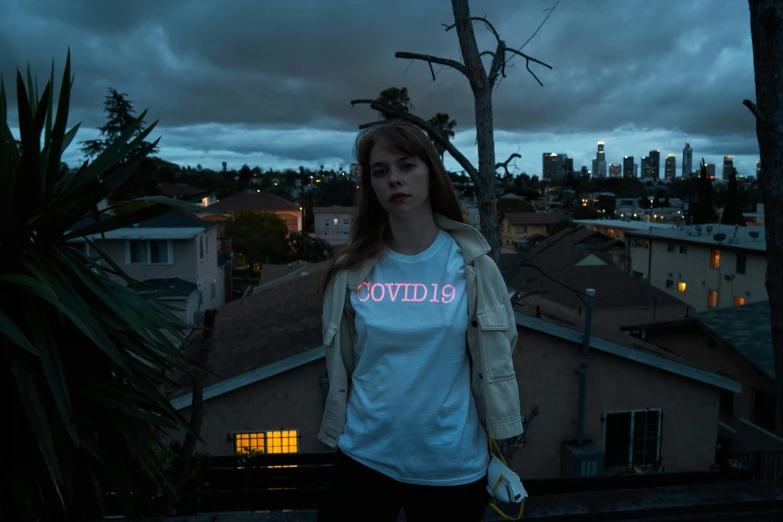 a woman standing on top of a roof next to a tree, inspired by Elsa Bleda, unsplash contest winner, graffiti, coronavirus, glow in dark, graphic tees, hollywood promotional image