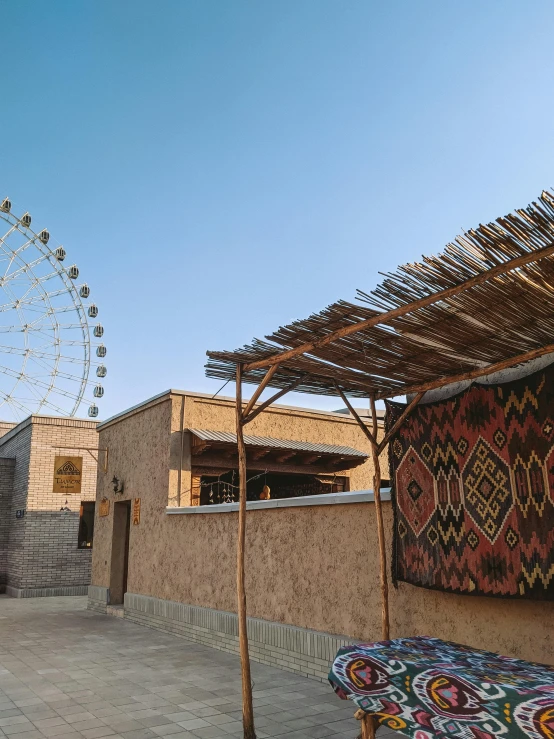 a building with a ferris wheel in the background, dau-al-set, rammed earth courtyard, rooftop party, high quality photo, weaving