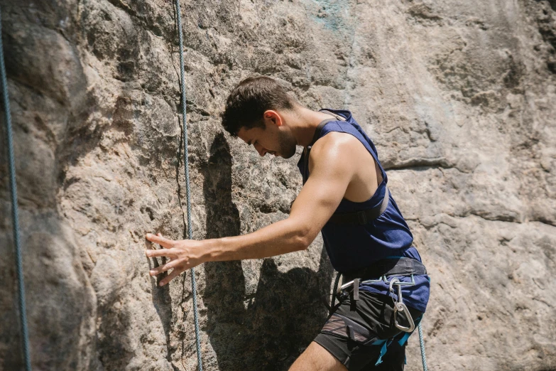 a man climbing up the side of a rock, a portrait, pexels contest winner, renaissance, body harness, avatar image, warm weather, mid-shot of a hunky