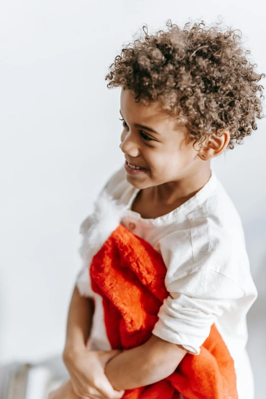 a little girl holding a teddy bear in her arms, an album cover, pexels contest winner, incoherents, wearing festive clothing, laughing, showing her shoulder from back, diverse