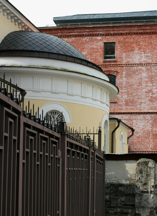 a red fire hydrant sitting in front of a building, inspired by Illarion Pryanishnikov, baroque, circular gate in a white wall, tombs, seen from a distance, rounded roof