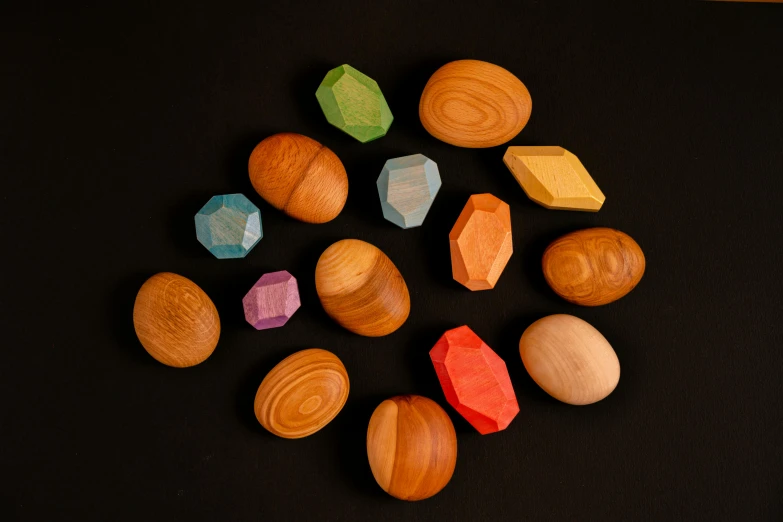 a bunch of wooden toys sitting on top of a table, ornate colored gems, 4 0 mm, ((rocks)), cedar