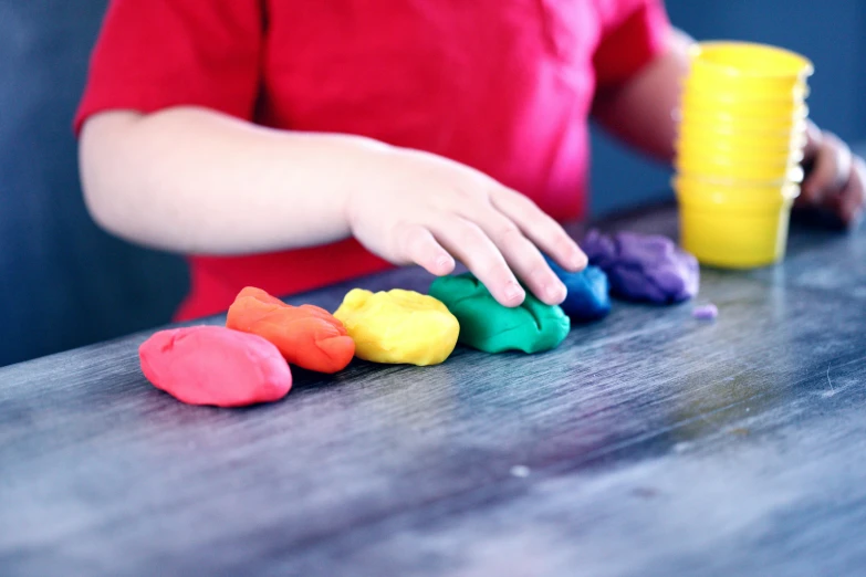 a child playing with play dough on a table, by Arabella Rankin, unsplash, rainbow colours, 15081959 21121991 01012000 4k, bump in form of hand, thumbnail