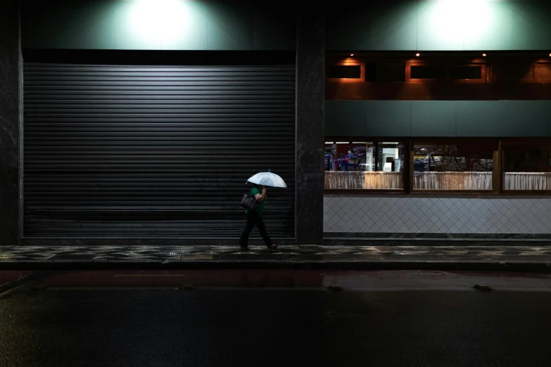 a person walking down the street with an umbrella, inspired by Elsa Bleda, são paulo, closed limbo room, in chippendale sydney, portrait featured on unsplash