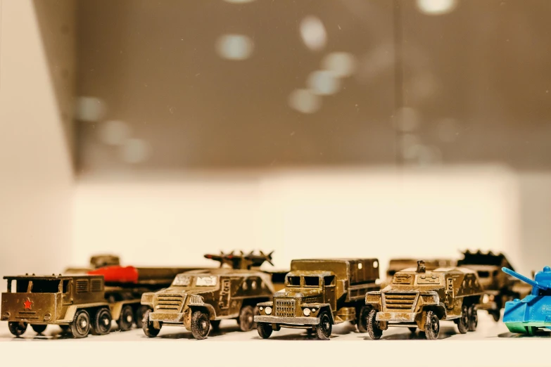 a group of toy vehicles sitting on top of a table, unsplash, photorealism, military parade, made of polished broze, truck, 33mm photo