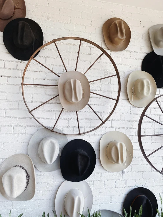 a bunch of hats that are on a wall, by Gavin Hamilton, kinetic art, white wheel rims, photo from behind of a cowboy, detailed product shot, background image